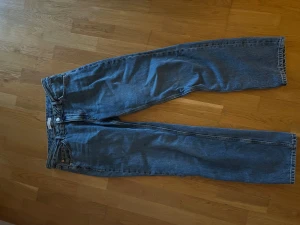 Low waist jeans - Klassiska jeans i blå denim med rak passform och normal midja. Byxorna har fem fickor, knappgylf. Perfekt för dig som gillar tidlös stil och vill ha ett par jeans som funkar till allt.