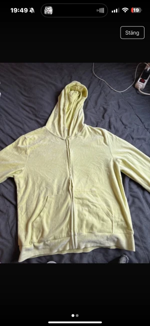 Ljusgul hoodie med dragkedja - Ljusgul hoodie med hel dragkedja framtill och två stora fickor. Tröjan har huva och är långärmad, perfekt för chill dagar. Mjuk bomullskänsla och enkel design som funkar till jeans eller mjukisbyxor.