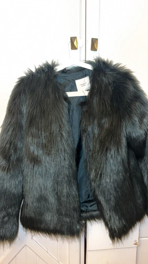 Mörkgrön  pälsjacka från Jacqueline de Yong - Säljer en mörkgrön pälsjacka från Jacqueline de Yong med lång, fluffig fuskpäls och mörkgrön insida. Jackan har en rak, lite boxig passform och långa ärmar. Perfekt för dig som vill ha en cool och trendig look med extra edge.