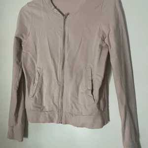 Beige och grå cardigan jacka 157 S - Två stilrena cardigan jackor från 157 i storlek S, en i beige och en i grå. Båda har dragkedja framtill, långa ärmar och praktiska fickor på sidorna. Perfekt för dig som gillar enkel och clean look. Materialet är mjukt och känns skönt mot huden.