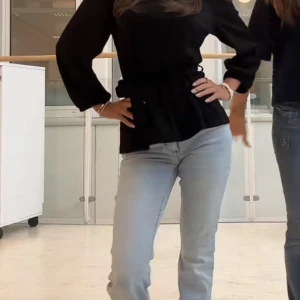 Svart omlottblus med knyt - Säljer en svart omlottblus från NA-KD med v-ringning och knyt i midjan. Blusen har långa, lite puffiga ärmar och ett lätt rynkat parti nedtill som ger en snygg siluett. Perfekt att styla med jeans eller kjol för en trendig look. Går att ha på två olika sätt.