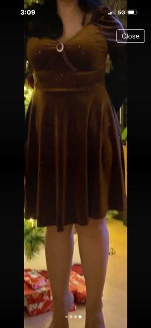 Brun glittrig sammetsklänning från SHEIN - Superfin brun kortklänning i mjuk sammet med glittriga detaljer. Klänningen har v-ringad omlottfront, markerad midja och långa puffärmar. Perfekt för dig som vill sticka ut med lite extra glitter. Snyggt flow i kjolen och bekväm passform.