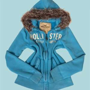 Hollister Fur Hoodie - ✨ Säljer en unik fur hoodie från märket (Hollister) ✨ Pälsen är ditsatt i efterhand för en personlig och trendig look. Storleken är (M), Eftersom plagget är second hand kan mindre defekter jag missat förekomma! – se gärna min bio för mer info.  💎 Priset är fast och ej förhandlingsbart.  Tvättråd: Handtvätta i ljummet vatten, var försiktig med pälsen, alternativt tvätta tröjan i en tvättpåse i tvättmaskinen 30-40grader. Undvik torktumlare. 