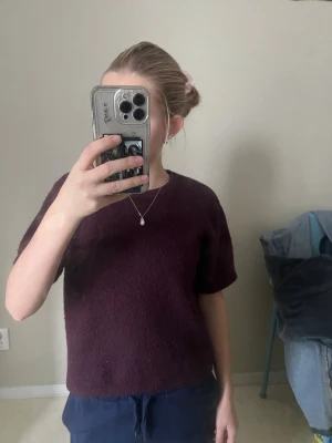 Vinröd stickad tröja Gina Tricot - Mysig vinröd stickad tröja från Gina Tricot med korta ärmar och rund hals. Tröjan har en enkel, loose passform och är tillverkad i ett mjukt stickat material som känns skönt mot huden. Perfekt för dig som gillar basic men ändå vill ha lite färg. Jag skulle säga att det är en blandning mellan lilla och vinröd.