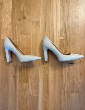 Stilrena klackar i blank nude färg  - Klassiska och stilrena klackar i blank nude färg – perfekta till både vardag och fest! Endast provade inomhus. Råkade få hem en i strl 36 och en i strl 37, men har knappt märkt skillnaden när jag provat dem.  👠 Storlek: 36 & 37 (ett par) 🤍 Färg: Nude / ljus beige 💛 Märke: NA-KD 📦 Skick: Som nya