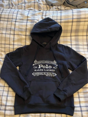 Mörkblå hoodie från Polo Ralph Lauren - Säljer en riktigt fet Hoddie från  Polo Ralph Lauren. Nästan alldrig använd finns inget märka på användning. Storlek M. Skirv vid fler bilder eller frågor. Perfekt som julklapp eller bara unna sig själv🌟💥Klicka på bilden när den sitter på så ser ni bättre💪🏻