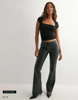 Svarta skinn  bootcut byxor  - Snygga svarta byxor med bootcut-snitt i skinn. Byxorna har låg midja, knapp och dragkedja framtill samt släta ben utan fickor. Väldigt skönt material. Helt nya, tog av prislappen & använda endast en gång 🥰 nypris: 599kr