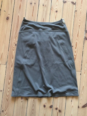 Grå kjol - Grå fin kjol med gult innertyg. Minns inte exakt storlek men skulle säga att den e satt som en 42a men lite mindre, passar mer m-l