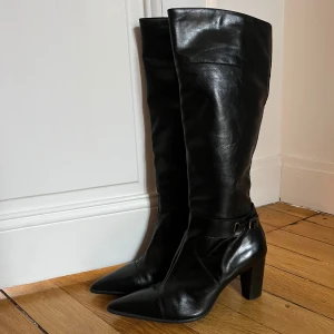 Svarta stövlar med klack och spetsig tå - Säljer ett par svarta höga stövlar i skinn med snygg spetsig tå och stabil klack. Bra kvalitet! 