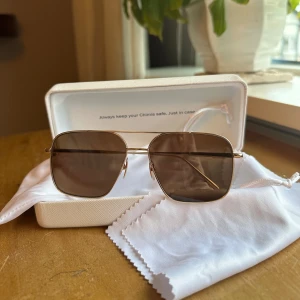 Guldiga solglasögon från Chimi - Snygga solglasögon från Chimi med fyrkantiga linser i mörkbrunt och tunn guldfärgad metallram. Sparsamt använda! Box, putsduk och påse medföljer ☺️