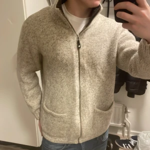 Beige/grå grå stickad cardigan - Riktigt snygg beige/grå stickad cardigan. Modellen är 180cm, 74kg. Priset kan såklart diskuteras!