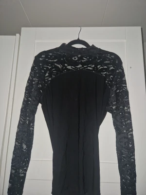 Svart spets top - Superfin svart topp med spetsdetaljer över axlar och längs hela ärmarna💕. Mjukt och bekvämt tyg som sitter snyggt på kroppen. Passar bäst för dig som brukar ha S–M🫶🏼. I mycket fint skick och perfekt till både vardag och fest!🫰🏼  Storlek: S/M Skick: Mycket bra den var ifrån gina tricot (Klippte av lappen störde mig)