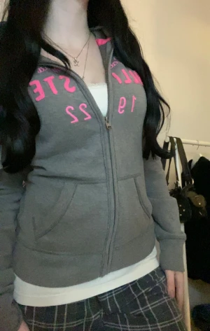 Snygg grå och rosa Hollister zip up - Storlek:M men passar som S, super skick med tanke på att den är ”vintage”.