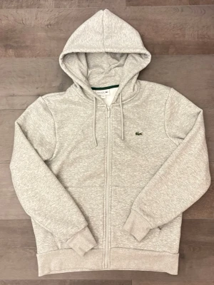 Lacoste hoodie - Riktigt skön grå Lacoste hoodie. Väldigt mjuk och varm. Aldrig använd, säljs då den ej passade mig. Hör av er vid frågor ☺️