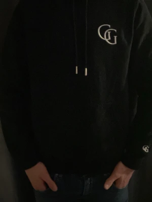Svart hoddie från Gardegrish med snöre  - Säljer nu en svart hoddie från gardegrish i mycket bra skick till ett bra pris. (Knappt använd)
