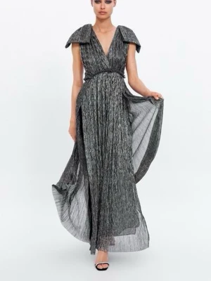 KLÄNNING MED METALLTRÅD LIMITED EDITION - Säljer en maxad glittrig långklänning i silver och svart med djup v-ringning och breda axelpartier. Klänningen har ett plisserat tyg som ger ett snyggt fall och markerad midja. 