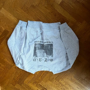 Grå sweatshorts från Stay - Säljer ett par grå sweatshorts från Stay med tryck och broderad text. De har en loose passform, bred resår i midjan och är tillverkade i mjuk bomull. Perfekta för chill dagar eller när du vill vara extra bekväm.