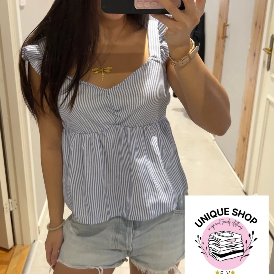 Blårandig blus med volangaxlar