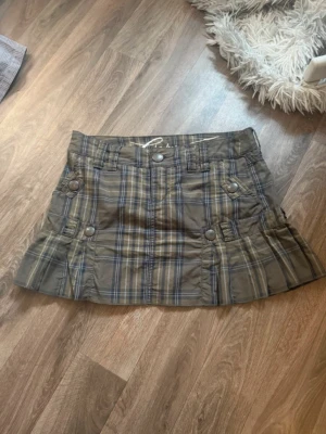 Rutig kortkjol från Esprit Str XS - Säljer en rutig kortkjol från Edc by Esprit. Kjolen har fickor med knappar fram och bak, samt breda hällor för bälte. Materialet är mjuk bomull och kjolen har plisserade detaljer nedtill för extra stil. Super snygg💕