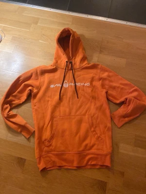 Hoddie - En orange sail raicing hoddie som är i bra skick. Tröjan är i storlek s och är en skön tröja med ull på insidan och passar när som hällst.