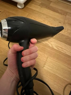 BaByliss  Hårfön - Kraftfull BaByliss hårfön, modell S272a, 2300W. Utrustad med EU-kontakt och ergonomiskt handtag. Svart design med kromdetaljer. Synligt i gott skick utan större slitage eller defekter. Perfekt för snabb och effektiv hårtorkning.