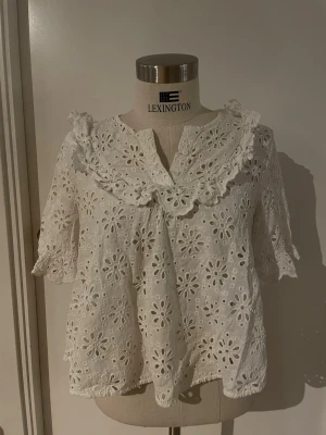 Vit sommar blus - En super söt vit sommar tröja med ut skjärda blomm mönster och spätts längst kragen