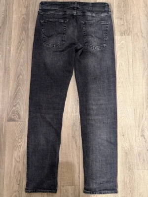 Jack & Jones Tapered Mike Jeans Grå W31 L34 - Gråa Jack & Jones Tapered Mike jeans i mycket fint skick i storlek W31/L34. Mått - Midja: 41cm, Benlängd: 106,5cm. Modellen är 185cm & 63kg. Hör av dig vid funderingar!🤩