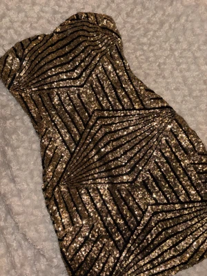 Glittrig guld klänning - Säljer min paljettklänning i guld då den inte kommer till användning. Den är i bra sick då jag användt den få gånger. 