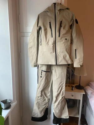 Skaljacka och skalbyxor från 8848 - Skaljacka och skalbyxor som är använda en månad. Öppningar vid armhålan och sida av låren finns samt ficka på bröst, lår, ena armen för liftkort samt innerficka i jacka. Snöskydd finns samt hängslen som går att ta av. Lite slitet vid ena bröstfickan men syns knappt. Även märken vid slutet av byxorna på baksidan från pjäxor. Jacka storlek 34 och byxor storlek 36.