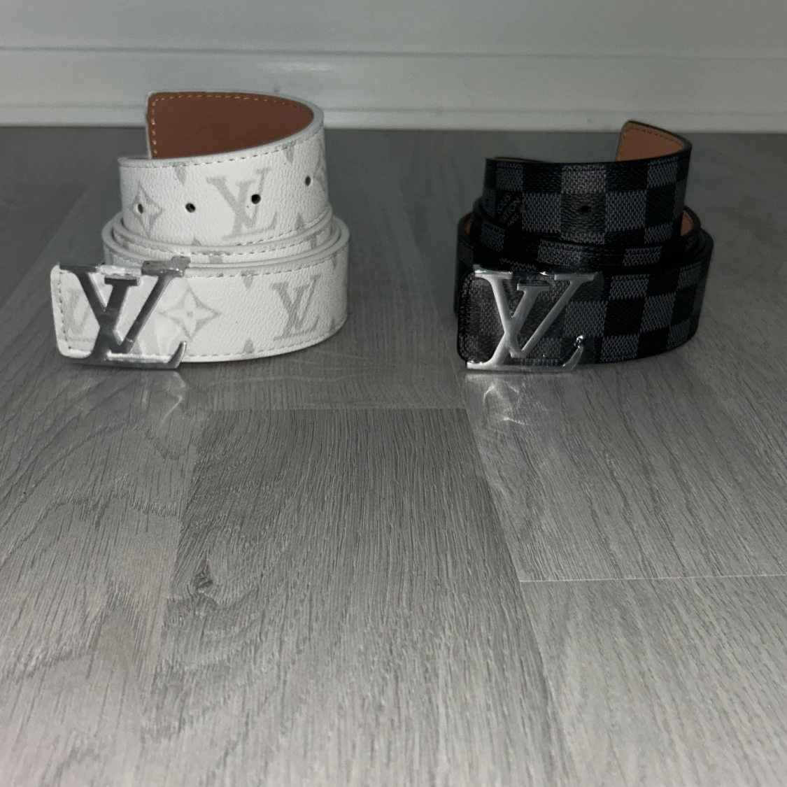 2 bälten från Lindex med L mönstrar