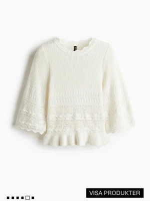 Vit stickad topp med volangkant - Säljer en söt vit stickad topp med trekvartsärmar och volangkant nedtill. Tröjan har ett fint hålmönster och ribbstickade detaljer upptill. Perfekt för dig som gillar en feminin och trendig stil.