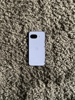 Google Pixel vit Android-telefon - Säljer en stilren Google Pixel med vit baksida och svart framsida. Telefonen har en enkel och modern design med rundade hörn och glasbaksida. Kameran och blixten sitter i övre vänstra hörnet på baksidan. Perfekt för dig som gillar Android och snygg design.