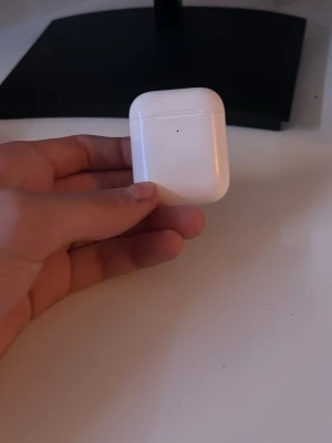 Vita Apple AirPods  - Säljer ett par stilrena vita Apple AirPods med matchande laddningsetui. De är trådlösa och har en smidig, kompakt design i blank plast som är enkel att ta med sig överallt. Perfekta för musik, poddar. Det fungerar dock inte att prata med de för att man hör inte dig genom airpodsen