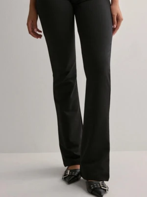 Svarta bootcut byxor i bomull - Snygga svarta bootcut byxor med klassisk passform och lätt utsvängda ben. Tillverkade i mjukt bomullsmaterial som ger en skön känsla hela dagen. Perfekta att styla med klackar eller boots för en trendig look.