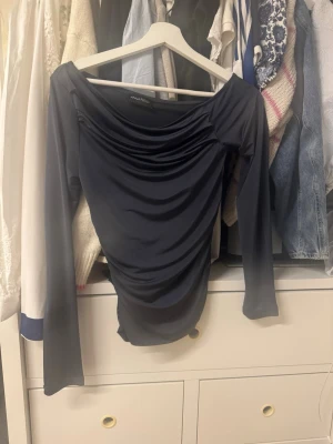 Svart omlottopp från Anna Field - Snygg svart omlottopp från Anna Field med draperad effekt och lång ärm. Toppen har en elegant, åtsittande passform och är perfekt att styla med jeans eller kjol. Materialet är mjukt och stretchigt för en bekväm känsla.