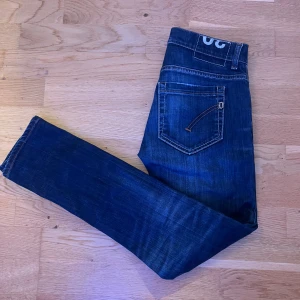 Mörkblå jeans med kontrastsömmar - Snygga mörkblå jeans med kontrastsömmar och unika detaljer på bakfickorna. Klassisk femficksmodell med raka ben och normal passform. Perfekta för dig som vill ha en stilren men ändå cool look.