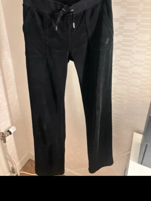 Juicy Couture velour sweatpants  - Juicy Couture klassiska mjukisbyxor i strl XS. Använda en del men men inget generellt slitage mer än att ena grejen på snöret fallit av. Köpta i butik för 1099kr för några år sen. Kvitto finns ej kvar. Jättesköna vardagliga byxor med sammetsmaterial