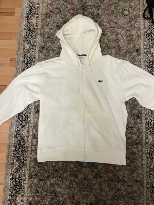 Vit zip hoodie från Lacoste - Storlek L men är stor i storlek så den sitter som L/Xl