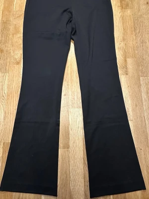 Svarta bootcut leggings U.S Polo Assn. - Snygga svarta leggings med bootcut-modell som ger en trendig siluett. Perfekta att matcha med en oversized hoodie eller crop top. Mjukt och stretchigt material för maximal komfort hela dagen.