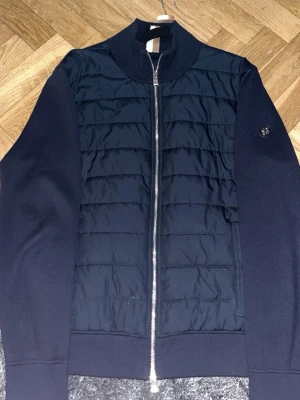 Cardigan från BOSS - En navy blue cardigan från BOSS köpt i butik på mall of scandinavia för 3799 kr. Endast använd upp mot 20 gånger.  Lappen har ramlat av pga svag kvalitet där det fäster men inget problem att sy tillbaka den själv. Storlek L. Annars väldigt bra kvalitet och inte något fel. PRIS KAN DISKUTERAS!