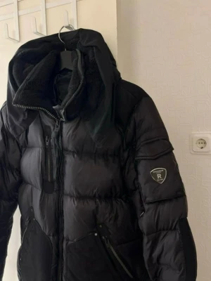 Svart dunjacka Rockandblue dam - Svart dunjacka från Rockandblue med stor huva fodrad i mjuk teddy. I princip nytt skick, använd enstaka gång pga fel storlek.