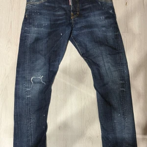 Dsquared2 blå twist jeans 16Y - DSQUARED Twist Jeans i storlek 16Y, nästan nya – har bara använts 1 gång då dem ör för små för mig. Mörkblå med twist-detalj och klassisk tvätt. 100% bomull.  Storlek 16Y motsvarar ca 164–170 cm i längd och midja ca 70–76 cm. Kan även passa XS/34 i dam/tånår storlek för smalare passform W27-W30 i herrstorlek  Köpta för 1800 kr, säljes nu till ett bra pris. Perfekta för vardag eller fest – ett fynd för dig som vill ha premiumjeans i toppskick!