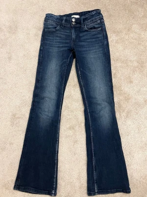 Mörkblå bootcut jeans - Säljer ett par mörkblå jeans med bootcut passform och klassisk femficksdesign från Gina Tricot i storlek 152 tall eftersom de blivit för små. Perfekta för en avslappnad och trendig look. Hör av er vid funderingar🙌🏼pris går alltid att diskuteras💕