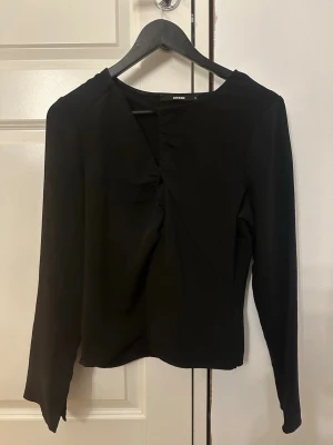 Svart långärmad blus från bikbok  - Stilren vit omlottblus från BikBok med lång ärm och unik twistad detalj framtill. Bra skick! 