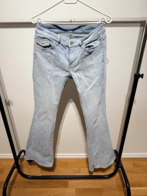 Ljusblå bootcut jeans med fickdetaljer från Monki  - Snygga ljusblå jeans med bootcut passform och coola fickdetaljer både fram och bak. Jeansen har klassisk femficksdesign och är tillverkade i mjukt denimtyg. Perfekta för dig som gillar en avslappnad men trendig stil.