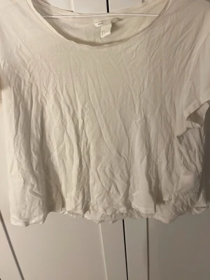  t-shirt från H&M  Basic - En enkel croppad t-shirt från Basic med rund halsringning och korta ärmar. Tillverkad i mjuk bomull, perfekt för en avslappnad och clean look. Passar till allt och är lätt att styla med olika outfits.