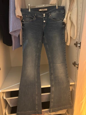 Low waist bootcut jeans  - Säljer ett par blå bootcut jeans från Twenty Easy med låg midja. Jeansen har klassiska fickor fram och bak, samt en snygg utsvängd passform. Perfekta för dig som gillar retrovibbar och vill ha ett par riktigt schyssta jeans. Dom jag har på bilden är storlek 26 men dom som säljs är i stl 30. 