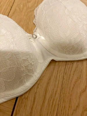 Vit spetsbh - Knappt använd vit spetsbh från hunkemöller med avtagbara remmar! Säljer då den är för liten runt om nu. Kostade ungefär 500