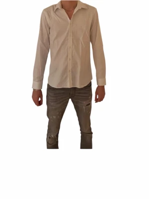 Vit skjorta från Bläck, tailored fit - Klassisk vit skjorta från Bläck i storlek L med snygg tailored fit. Skjortan har lång ärm, krage och knappar framtill. Perfekt för dig som gillar stilrena och enkla plagg. Materialet är mjukt och känns som bomull, vilket gör den skön att bära hela dagen.