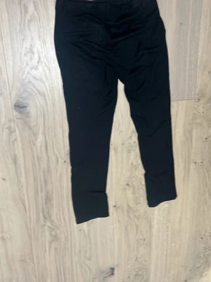 Svarta chinos med tapered passform - Svarta chinos med några få hål, och lite tunna. 